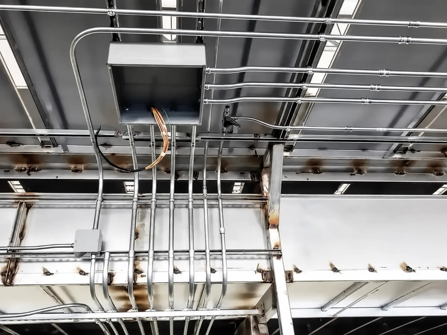 Electrical conduit and MEP piping system installed on industrial ceiling structure